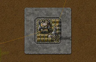 Detalhe da base de um roboport: o roboport, 14 baús de armazenagem, um poste grande e duas lâmpadas, capturado no jogo