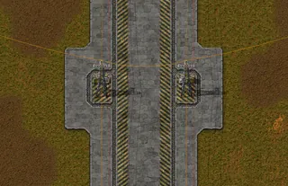 Detalhe da rua entre dois blocos: as bases dos postes da borda ficam frente a frente, uma espelhando a outra, com as faixas de perigo dos dois lados e um fio de cobre cruzando a rua, capturado no jogo